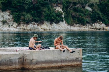 Saint-Jean-Cap-Ferrat, Fransa - 01 Haziran 2023: İnsanlar Saint-Jean-Cap-Ferrat 'taki en güzel plajlardan biri olan Fosses plajında dinleniyor