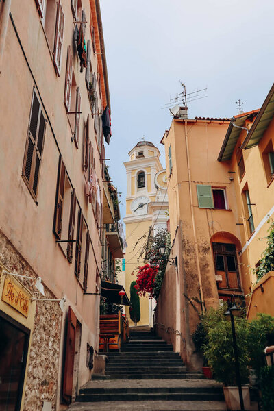Villefranche sur Mer, France - 01 June 2023: Beautiful bright orange and red facades in the city center of Villefranche sur Mer, on the French Riviera