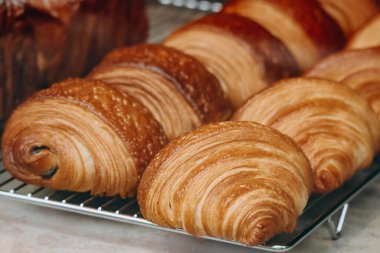 Bir pastanenin vitrininde taze ve güzel Fransız hamur işlerinin (kruvasan, acılı au chocolat) yakın çekimi.
