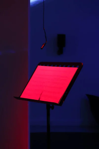 Music stand with text and microphone, recording studio
