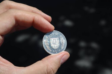 5 İsviçre frangının bir adamın elinde tuttuğu yakın plan fotoğrafı.
