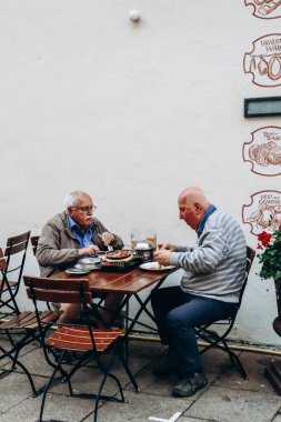 Fussen, Almanya - 14 Ağustos 2023: İki adam Fussen, Bavyera, Güney Almanya 'nın merkezindeki restoranda yemek yiyor
