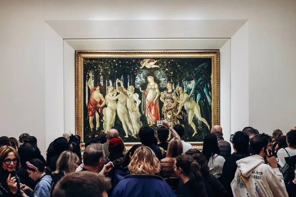 2023年12月29日 意大利佛罗伦萨 许多游客聚集在乌菲齐画廊的一幅波提切利油画周围 免版税图库图片