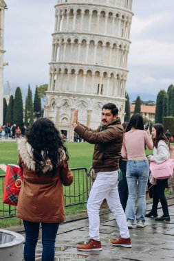 Pisa, İtalya - 30 Aralık 2023: Pisa Kulesi 'nde ortak poz veren turistler