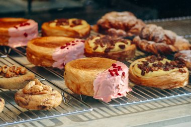 Bir pastanenin vitrininde taze ve güzel Fransız pastalarının yakın çekimi.