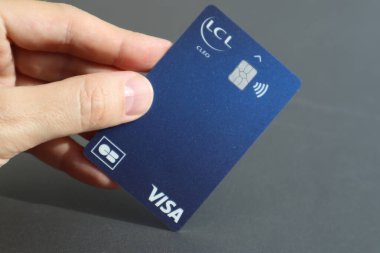 Nice, France - 11.05.2024: Visa banka kartı tutan bir adamın eli LCL (Credit Lyonnais)