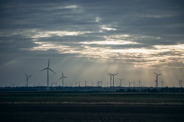 Bulutlu bir akşamda Avusturya 'daki tarlalarda rüzgar türbinleri