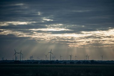 Bulutlu bir akşamda Avusturya 'daki tarlalarda rüzgar türbinleri