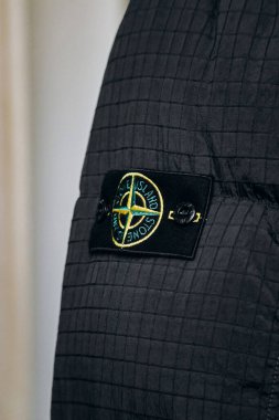 Nice, Fransa - 27 Temmuz 2024: Pusula ve rüzgar gülü içeren ünlü Stone Island marka kol bandının yakın çekimi.