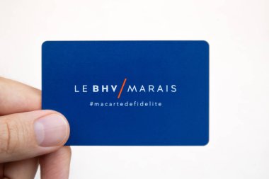 Paris, France - September 27th, 2024: Hand holding a loyalty card of the Parisian department store Le BHV Marais clipart