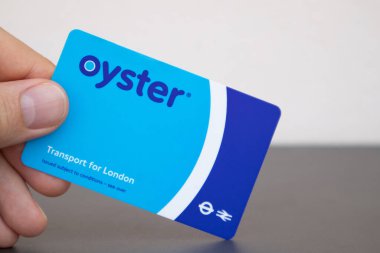 Man's hand holding a London transport card, named Oyster clipart