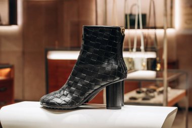 Bologna, İtalya - 6 Ekim 2024: Bottega Veneta botları bir butik vitrininde yapılan ünlü intrecciato tekniği