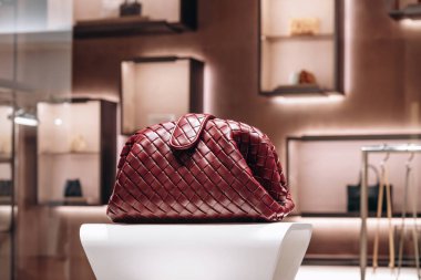 Bologna, Italy - October 6, 2024: Bottega Veneta bag made in the famous intrecciato technique in a boutique window clipart