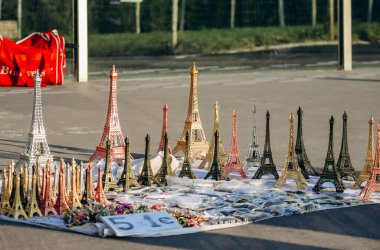 Paris, France - 15 July 2021: Souvenir Eiffel Tower figurines on the pavement in Paris clipart