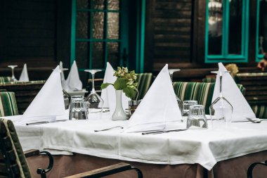 Elegantly Set Table with a White Tablecloth in a Restaurant clipart