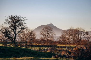 View of the famous Puy de Dome volcano from Plateau de Gergovie at winter sunset clipart