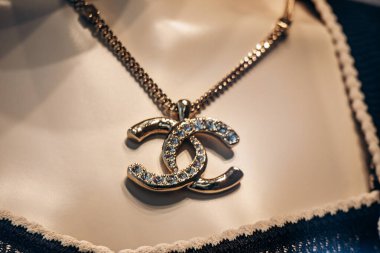 Milan, Italy - August 20, 2024: A Chanel pendant in a boutique window on the famous shopping street Montenapoleone in Milan. clipart