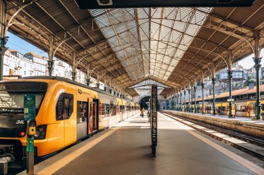 Porto, Portekiz - 28 Aralık 2024: Portekiz 'in Porto kentindeki Sao Bento istasyonunda Comboios de Portugal' in sarı treni