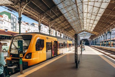 Porto, Portekiz - 28 Aralık 2024: Portekiz 'in Porto kentindeki Sao Bento istasyonunda Comboios de Portugal' in sarı treni