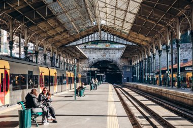 Porto, Portekiz - 28 Aralık 2024: Portekiz 'in Porto kentindeki Sao Bento istasyonunda Comboios de Portugal' in sarı treni