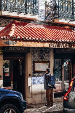 Lizbon, Portekiz - 28 Aralık 2024: Lizbon şehir merkezinde restoran menüsüne bakan bir turist