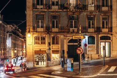 Lizbon, Portekiz - 2 Ocak 2025: Lizbon şehir merkezinde sıcak şehir ışıklarıyla aydınlatılmış bir caddenin gece manzarası