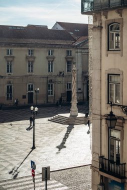 Lizbon, Portekiz - 2 Ocak 2025: Praca do Municpio Meydanı manzarası, güzel bükülmüş sütun heykeli, çevrede gezinen insanlar ve arka planda tarihi binalar