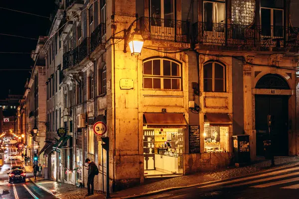 Lizbon, Portekiz - 2 Ocak 2025: Lizbon şehir merkezinde sıcak şehir ışıklarıyla aydınlatılmış bir caddenin gece manzarası