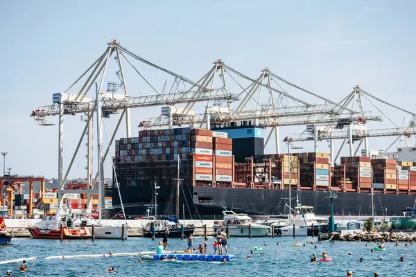 Koper, Slovenya - 16 Ağustos 2024: Adriyatik kıyısı boyunca yüzen insanlarla Koper Limanı manzarası