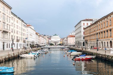Trieste, İtalya - 18 Ağustos 2024: Trieste 'deki Kanal Grande manzarası, tekneler ve rengarenk binalar rıhtımda.