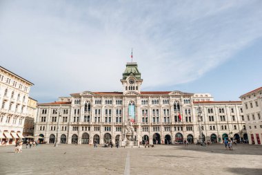 Trieste, İtalya - 18 Ağustos 2024: Piazza Unita dItalia 'daki tarihi Trieste Belediye Binası, büyük mimari ve merkezi saat kulesi