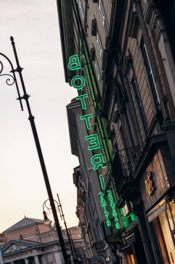 Trieste, İtalya - 18 Ağustos 2024: Aydınlatılmış neon tabela, binanın ön cephesinde Trieste 'nin kalbinde canlı bir parıltı bıraktı.