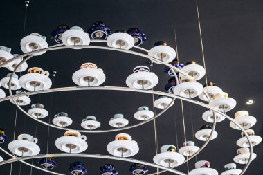 Trieste, İtalya - 18 Ağustos 2024 Trieste 'deki Illy Cafe' de asılı duran kahve fincanlarından yapılmış eşsiz bir avize.