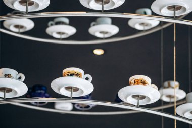 Trieste, İtalya - 18 Ağustos 2024 Trieste 'deki Illy Cafe' de asılı duran kahve fincanlarından yapılmış eşsiz bir avize.
