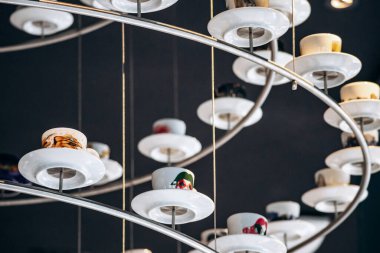 Trieste, İtalya - 18 Ağustos 2024 Trieste 'deki Illy Cafe' de asılı duran kahve fincanlarından yapılmış eşsiz bir avize.