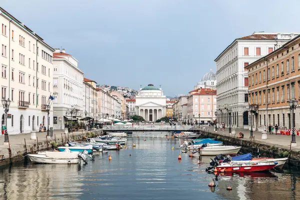 Trieste, İtalya - 18 Ağustos 2024: Trieste 'deki Kanal Grande manzarası, tekneler ve rengarenk binalar rıhtımda.