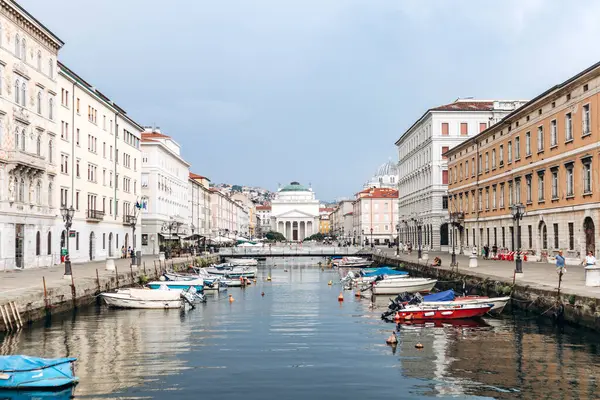 Trieste, İtalya - 18 Ağustos 2024: Trieste 'deki Kanal Grande manzarası, tekneler ve rengarenk binalar rıhtımda.