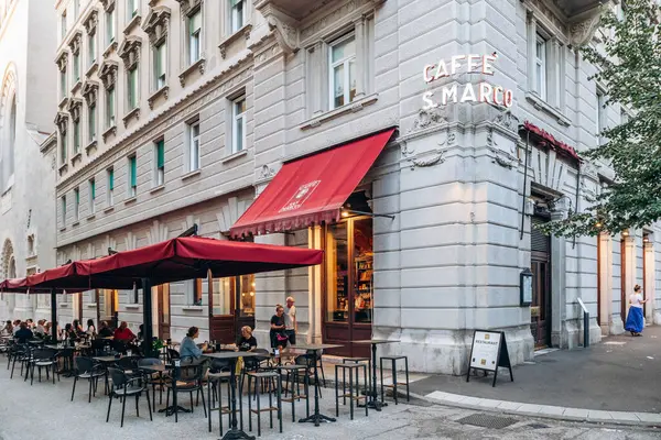 Trieste, İtalya - 18 Ağustos 2024: Trieste 'deki tarihi Kafe San Marco' nun cephesi ve terası