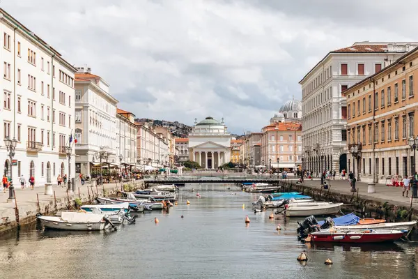 Trieste, İtalya - 18 Ağustos 2024: Trieste 'deki Kanal Grande manzarası, tekneler ve rengarenk binalar rıhtımda.