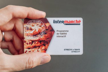 Güzel, Fransa - 5 Ocak 2025 Intermarche sadakat kartı tutan bir adam, müşteri ödülleri ve alışveriş yardımları sunuyor.