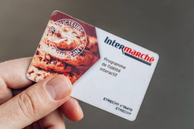 Güzel, Fransa - 5 Ocak 2025 Intermarche sadakat kartı tutan bir adam, müşteri ödülleri ve alışveriş yardımları sunuyor.
