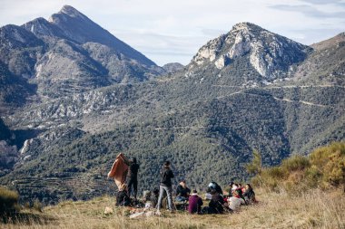 Menton, Fransa - 18 Ocak 2025: Bir grup turist Menton 'un yukarısındaki dağlarda yürüyüş yapıyor, Fransa-İtalya sınırında, Ocak ayında güney doğayla çevrili.