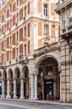 Cenova, İtalya - 22 Eylül 2024: Zarif arkalı cepheler ve şehrin ana alışveriş caddesi Via XX Settembre, tarihi binalar hattı.