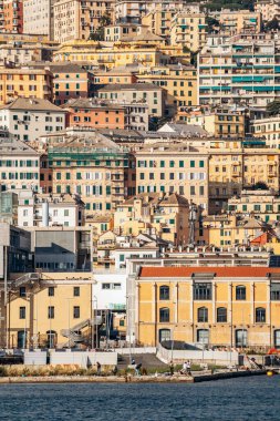 Ceneviz, İtalya - 22 Eylül 2024: Renkli yamaç cepheleri ve liman limanı üzerinde botlar ve yeşilliklerle kaplı tarihi binalar yükseliyor.