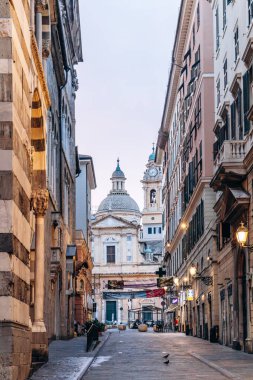 Cenova, İtalya - 22 Eylül 2024: San Lorenzo Katedrali 'nin kubbesi ve çan kulesine giden tarihi bir caddenin sabah manzarası