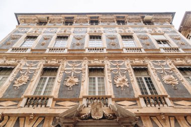 Cenova, İtalya - 22 Eylül 2024: UNESCO 'nun Dünya Mirası sitesi Via Garibaldi' de Rönesans pencereleri ve sütunları bulunan Palazzo Nicolosio Lomellino 'nun süslü dış cephesi.