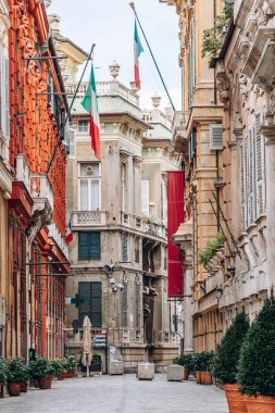 Cenova, İtalya - 22 Eylül 2024: Rönesans sarayları ve İtalyan bayrakları tarihi merkezdeki zarif yayalar Via Garibaldi 'nin hizasında.