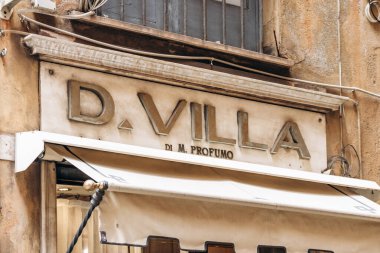 Cenova, İtalya - 22 Eylül 2024: Vintage mağaza tabelası D. Villa di M. Profumo tarihi merkezdeki yıpranmış taş cephesinde yükseltilmiş harflerle birlikte.