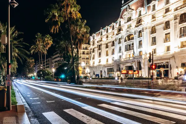 Nice, Fransa, 16 Eylül 2024: Nice 'teki Negresco Oteli' nin gece manzarası trafik ve palmiye ağaçlarının ışık izleriyle.