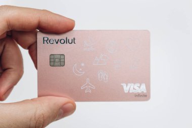Paris, Fransa - 23 Şubat 2025: Modern bankacılık ve dijital ödeme hizmetlerinin sergilendiği kişiselleştirilmiş pembe Revolut banka kartı.